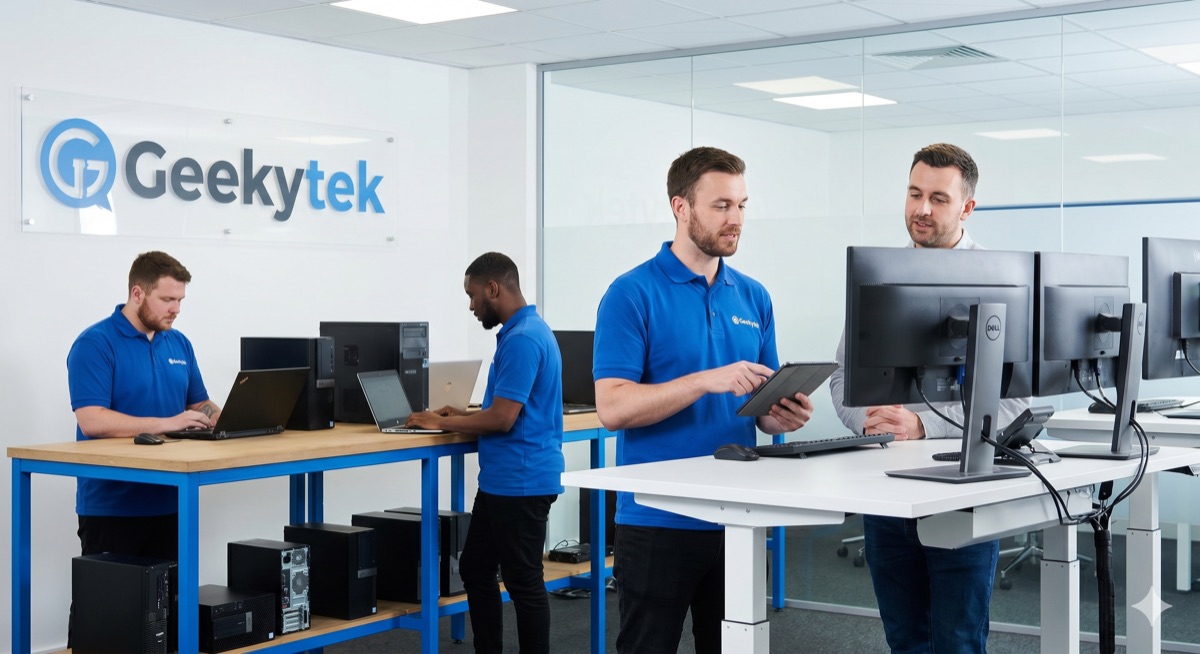 Technicians working at standing desks inside the Geekytek office